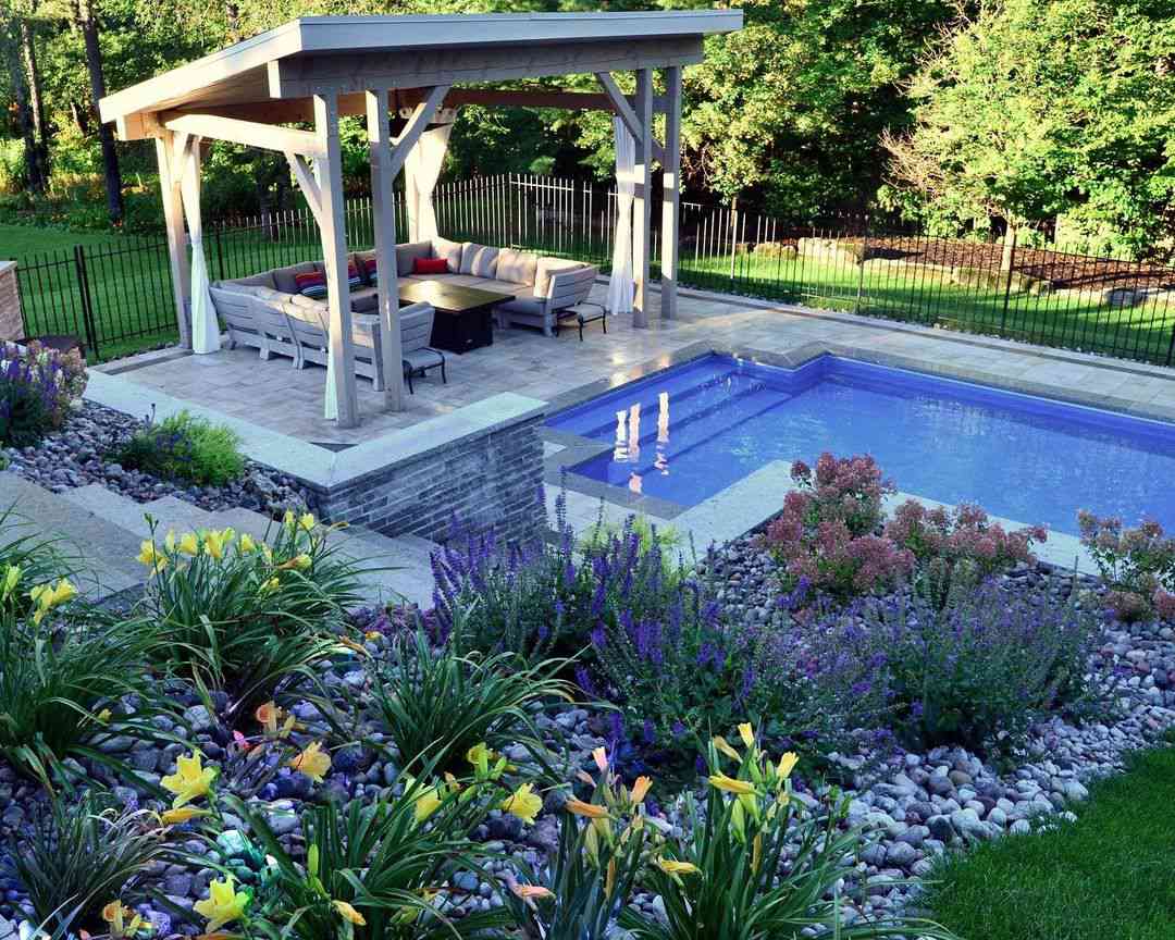 Uma piscina no quintal com um jardim elevado