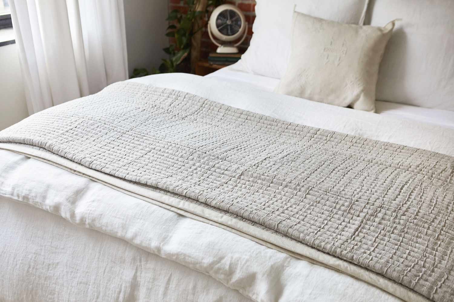 Leichte hellbraune und weiße Decken auf dem Bett gefaltet