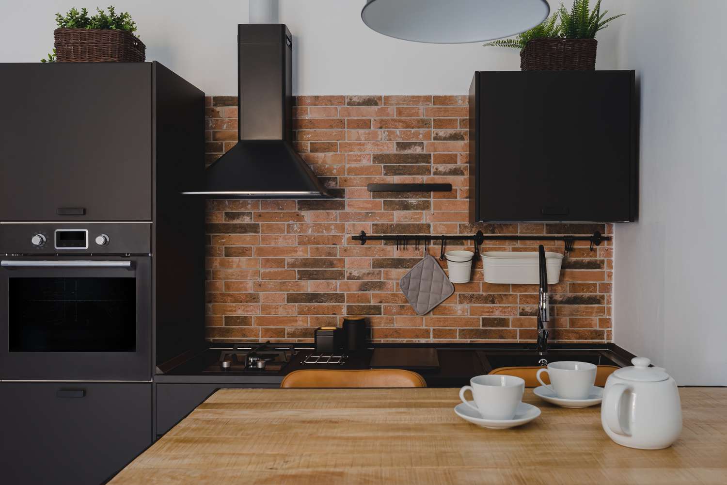 Black stainless steel appliances in brick wall kitchen