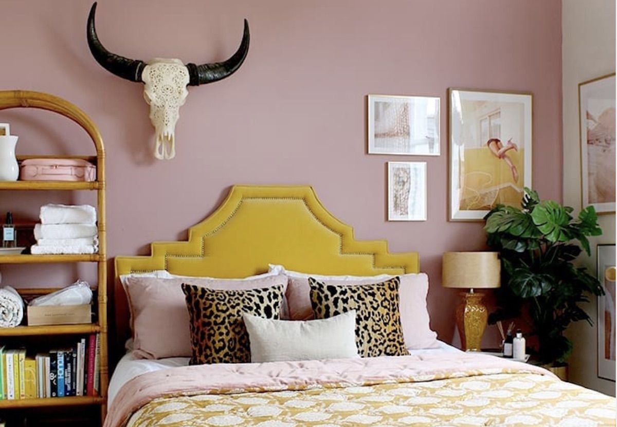 Boho-Western-Schlafzimmer mit rosa Wänden, gelbes Kopfteil