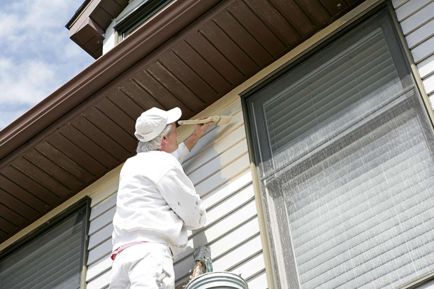 Empreiteira pintando o exterior da casa