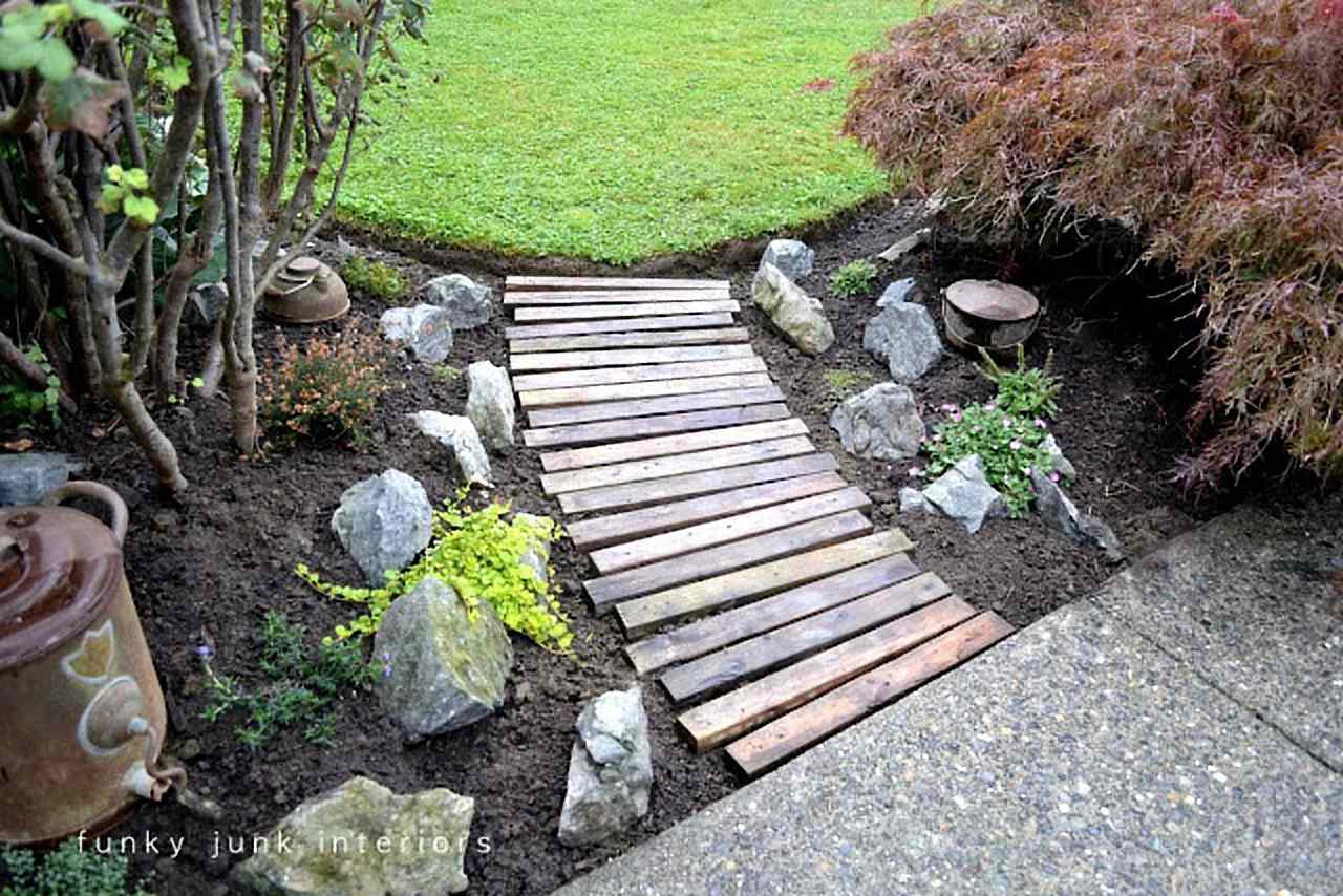 Caminho de jardim feito com tábuas de madeira revestidas de pedras