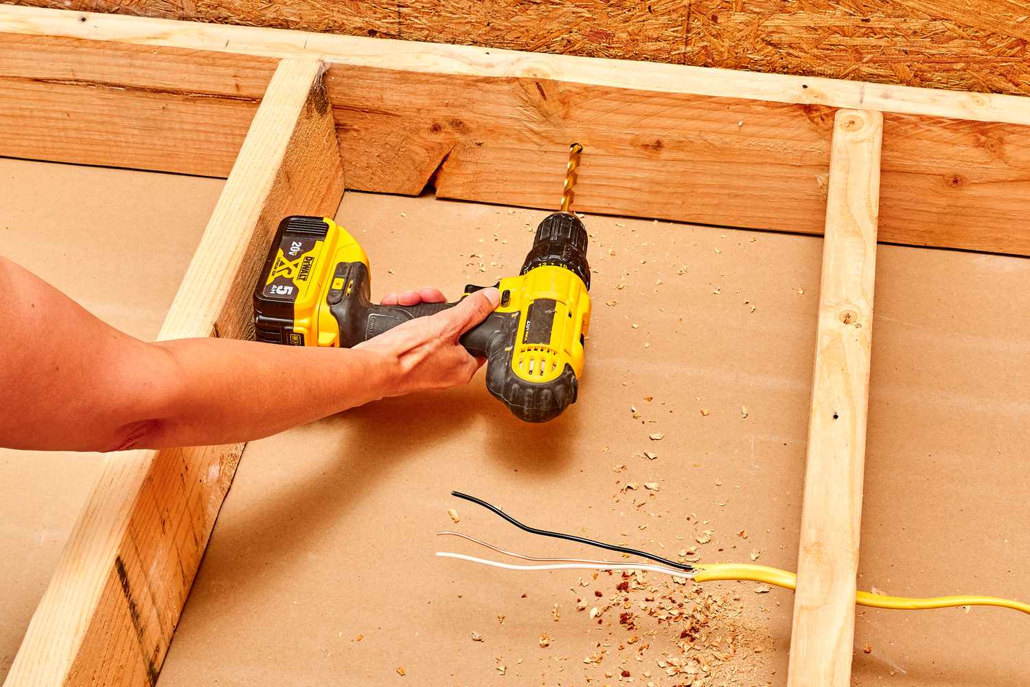 Electric drill making locator hole within wood stud for vent point