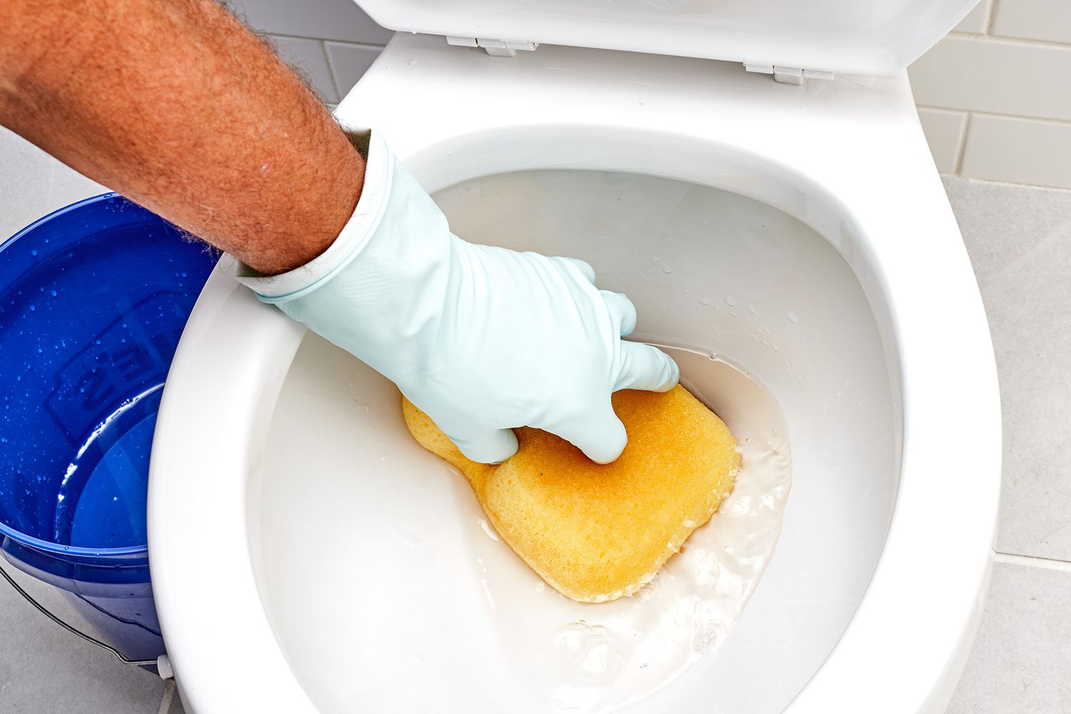 Toilette en cours de vidange avec une éponge jaune absorbant l'eau