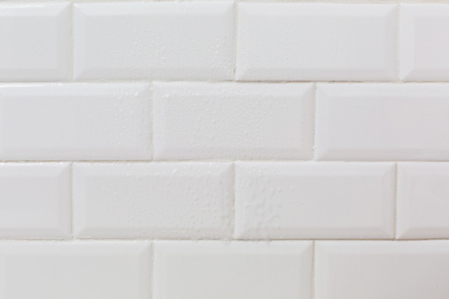 Mur en carrelage blanc avec solution de nettoyage pulvérisée