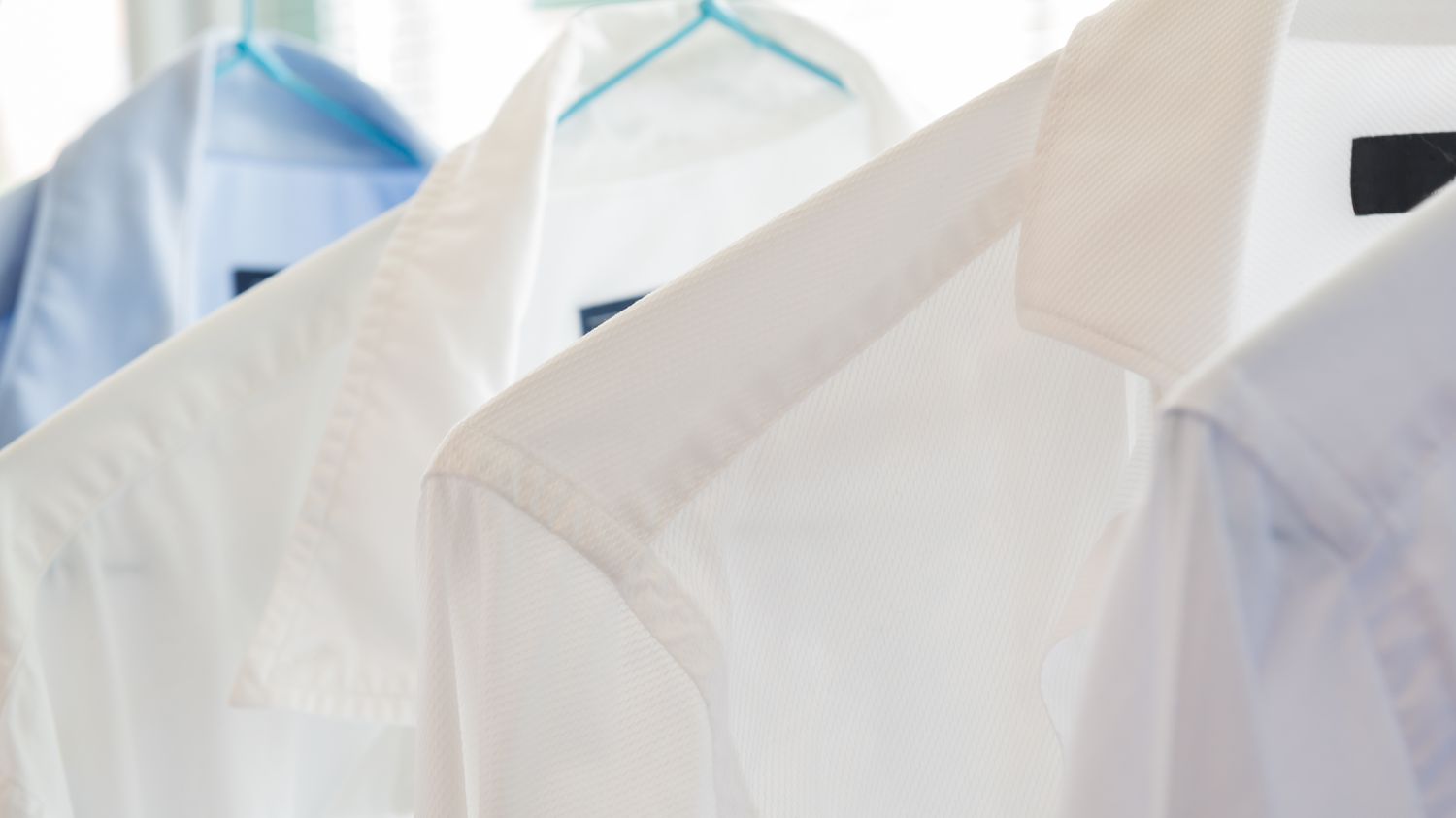 Camisas brancas e azuis em uma lavanderia a seco