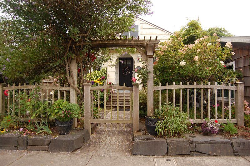 Valla de madera desgastada y pérgola de entrada en casa de campo en la playa