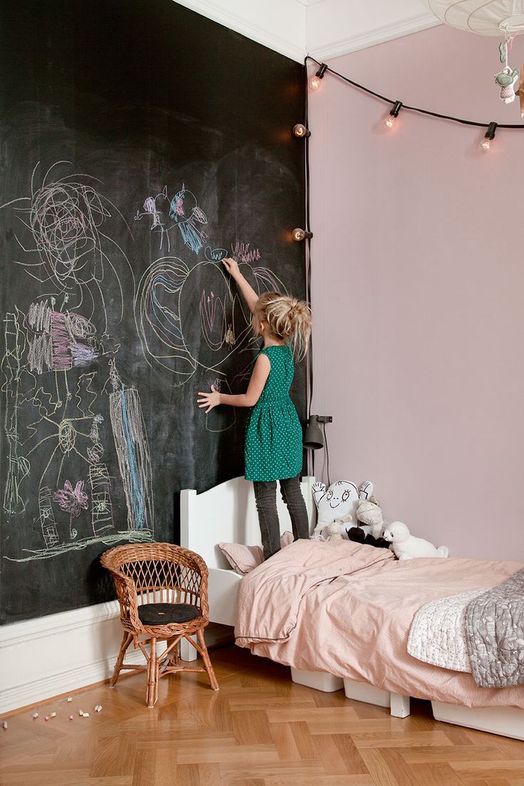 Quarto de menina rosa e preto com parede de realce de quadro-negro