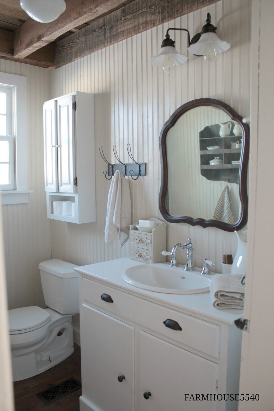 Um banheiro com painéis de madeira em estilo rústico de casa de fazenda