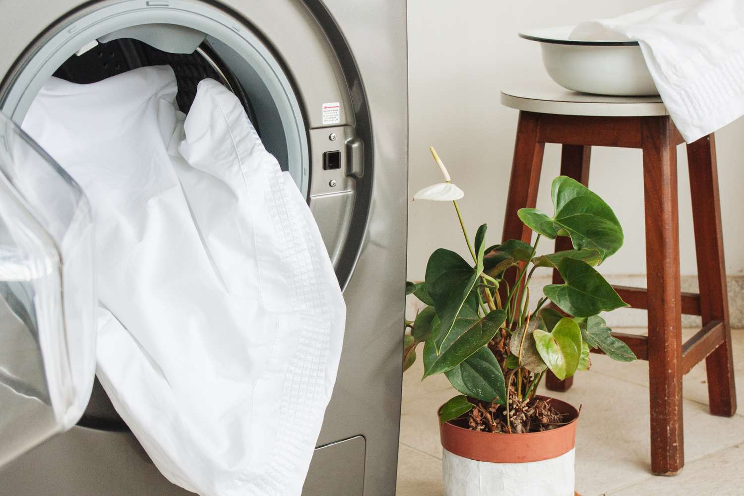 Schmutzige Bettwäsche in die Waschmaschine geben