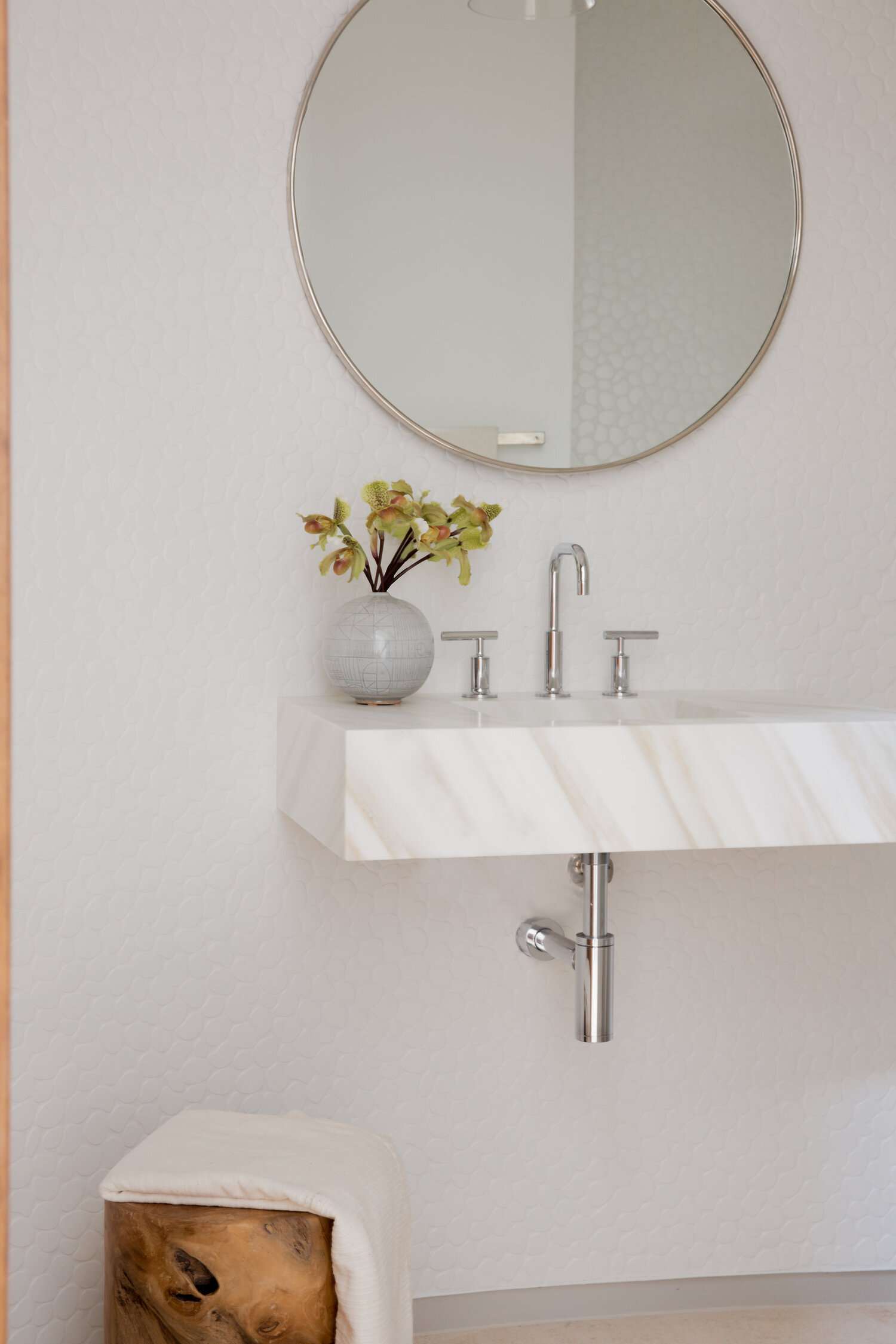 salle de bain blanche avec lavabo flottant en marbre blanc