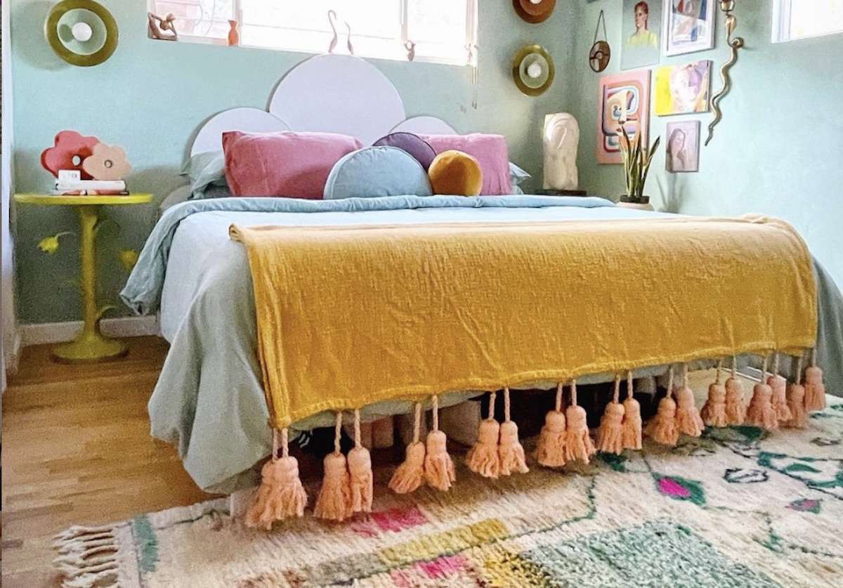 quarto colorido e divertido com cama amarela, decoração floral e tapete estampado