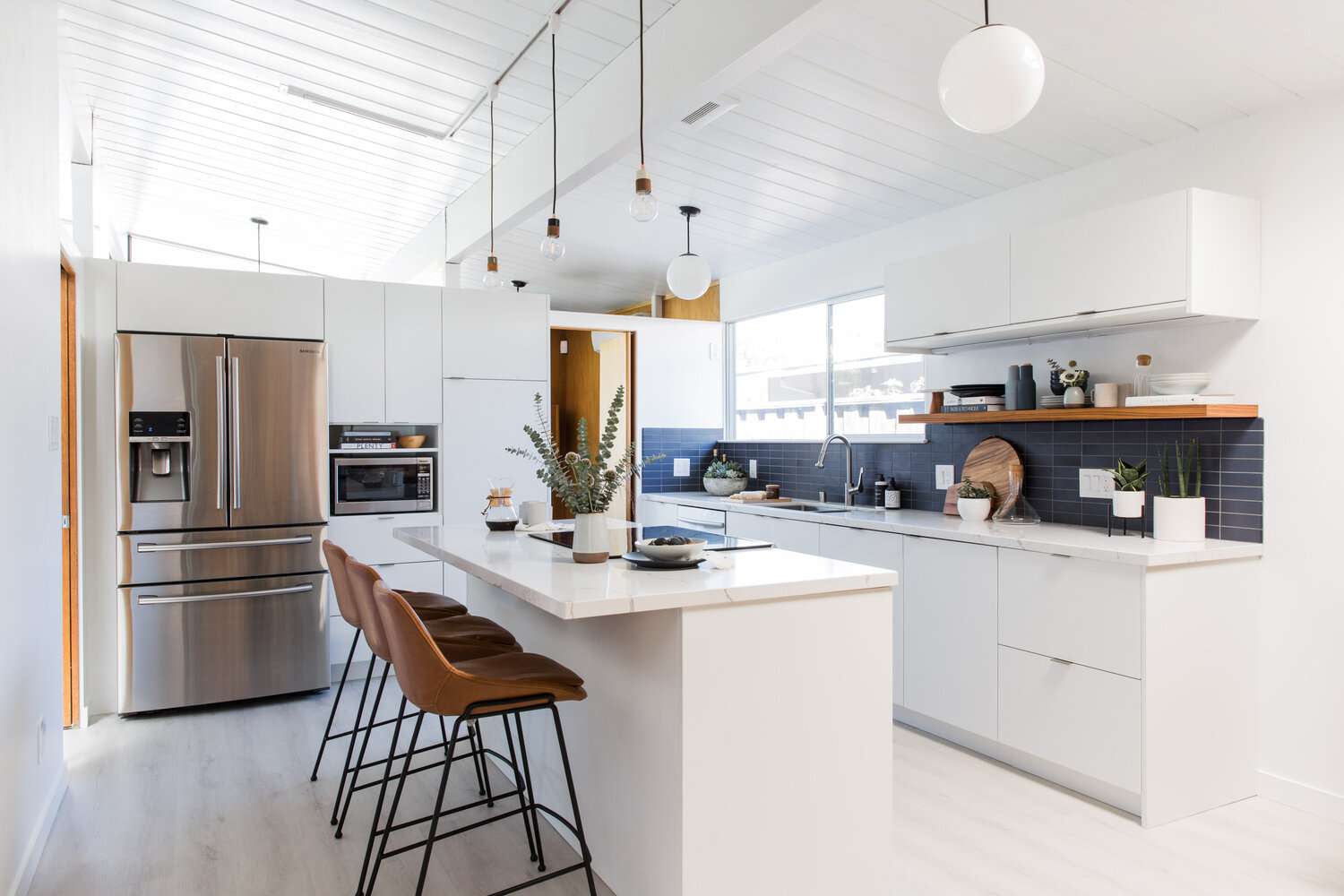 modern white kitchen with navy blue tile backsplash