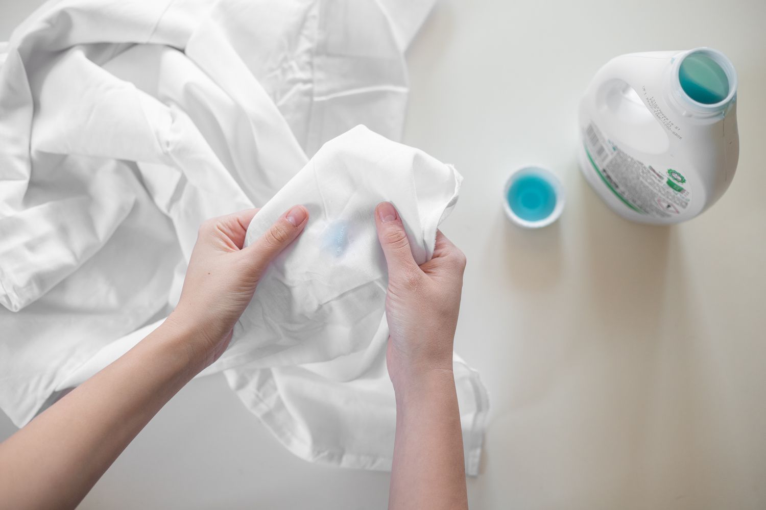 Taches sur draps blancs prétraitées avec de la lessive pour gros travaux 