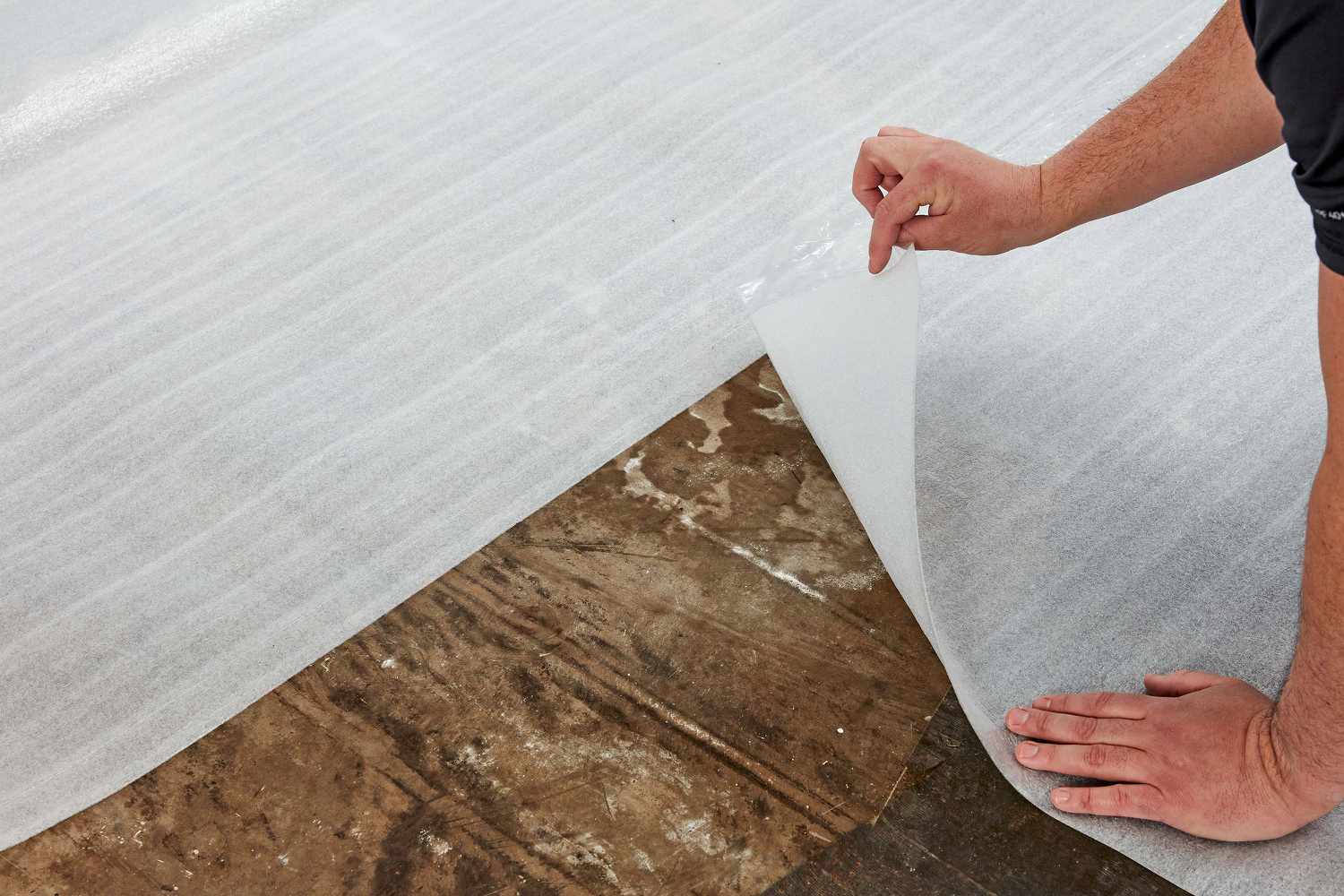 Underlayment being placed on subfloor