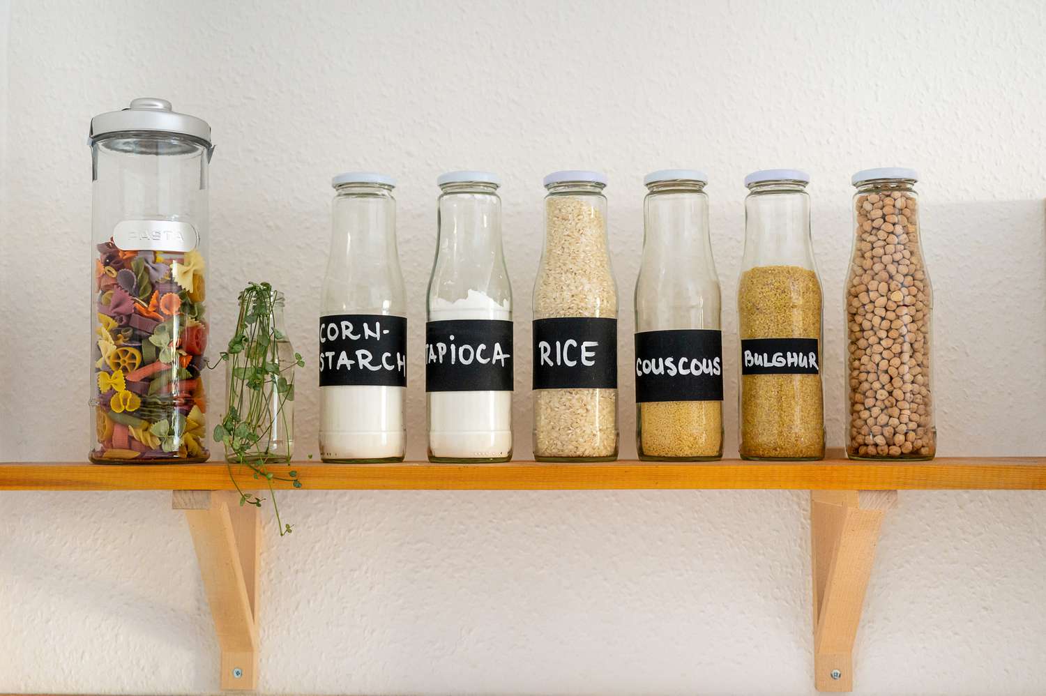 Dicht verschlossene Glasbehälter mit verschiedenen Lebensmitteln beschriftet im Küchenregal