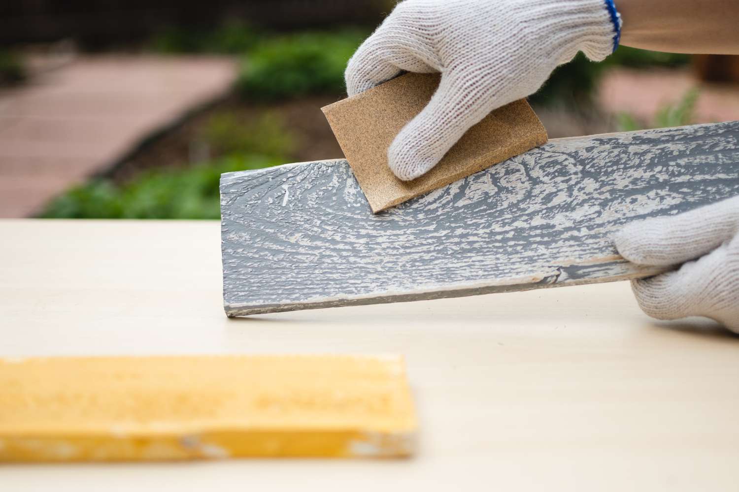 Tabla de madera lijada después de aplicar la pintura para darle un aspecto envejecido