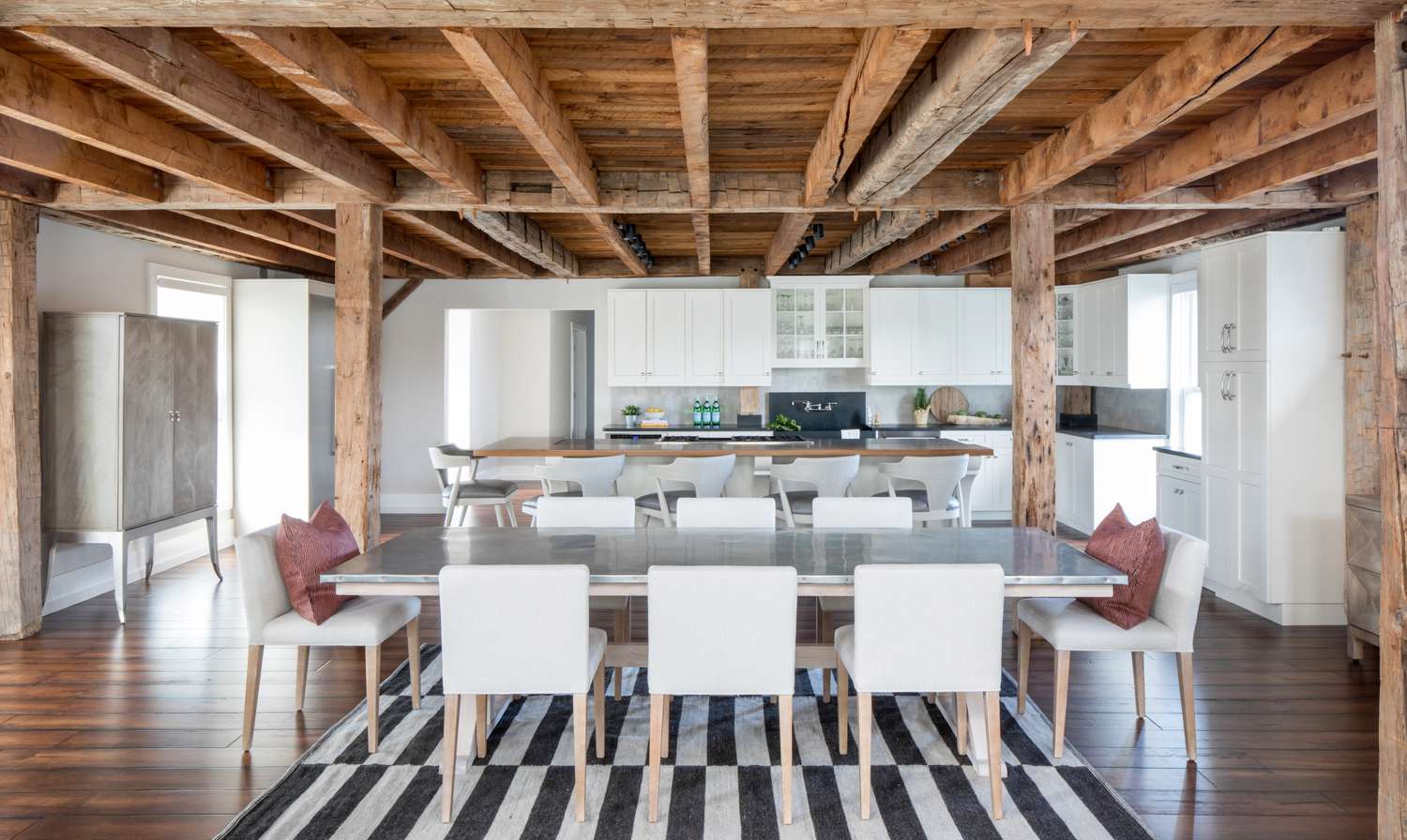 Belle salle à manger avec poutres en bois apparentes et plafond.