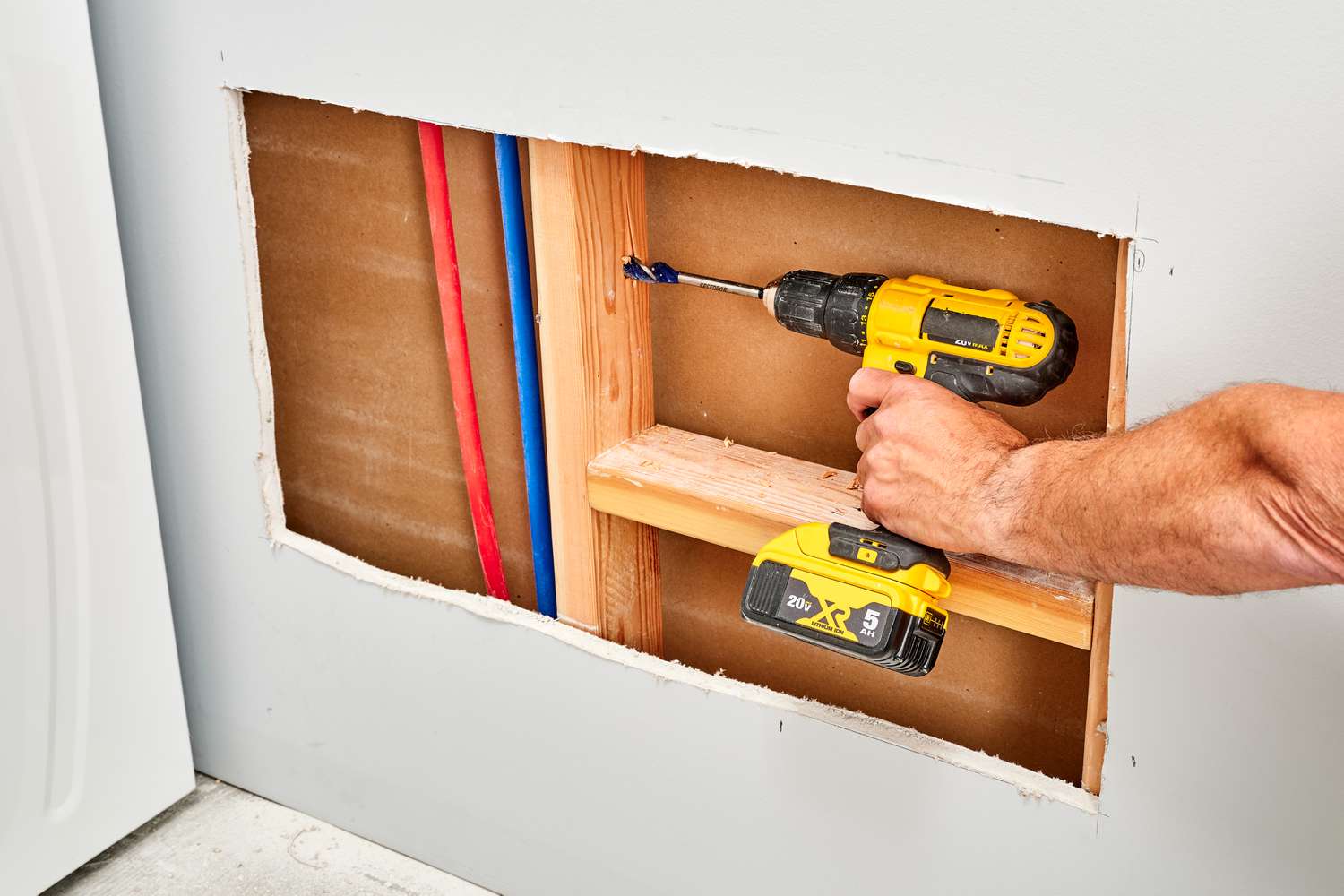 Holes drilled into wall studs where laundry sink will be placed