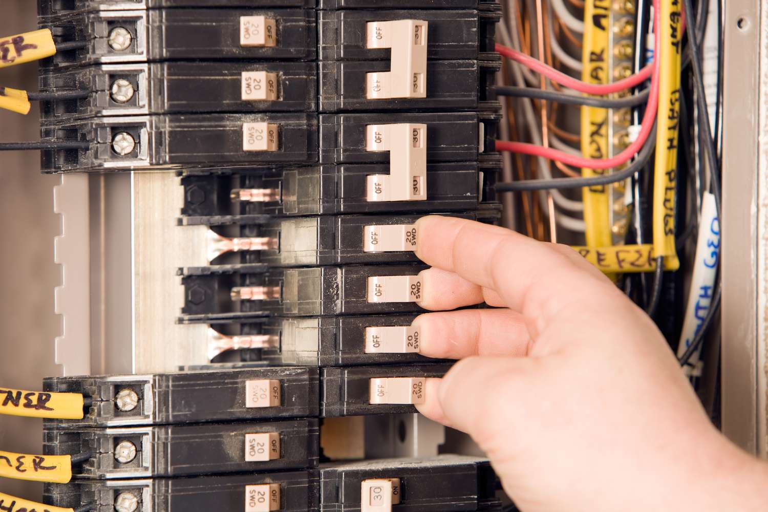 Electricians hand turning on circuit breakers