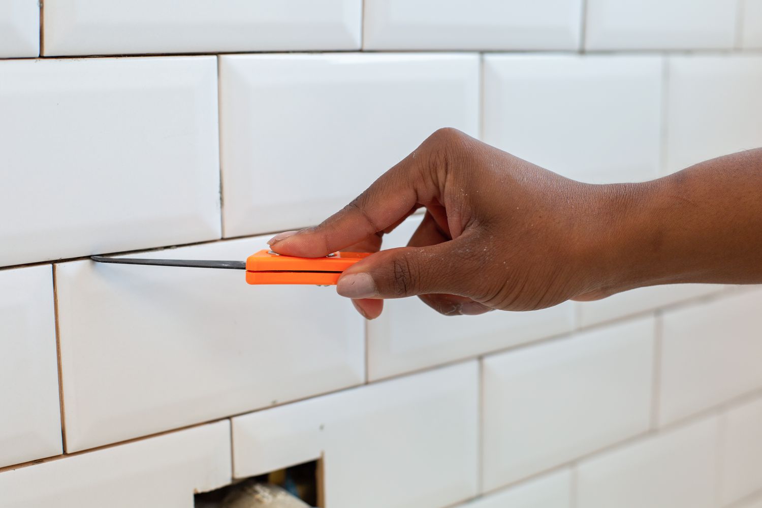 Joints de coulis inspectés avec un couteau utilitaire orange