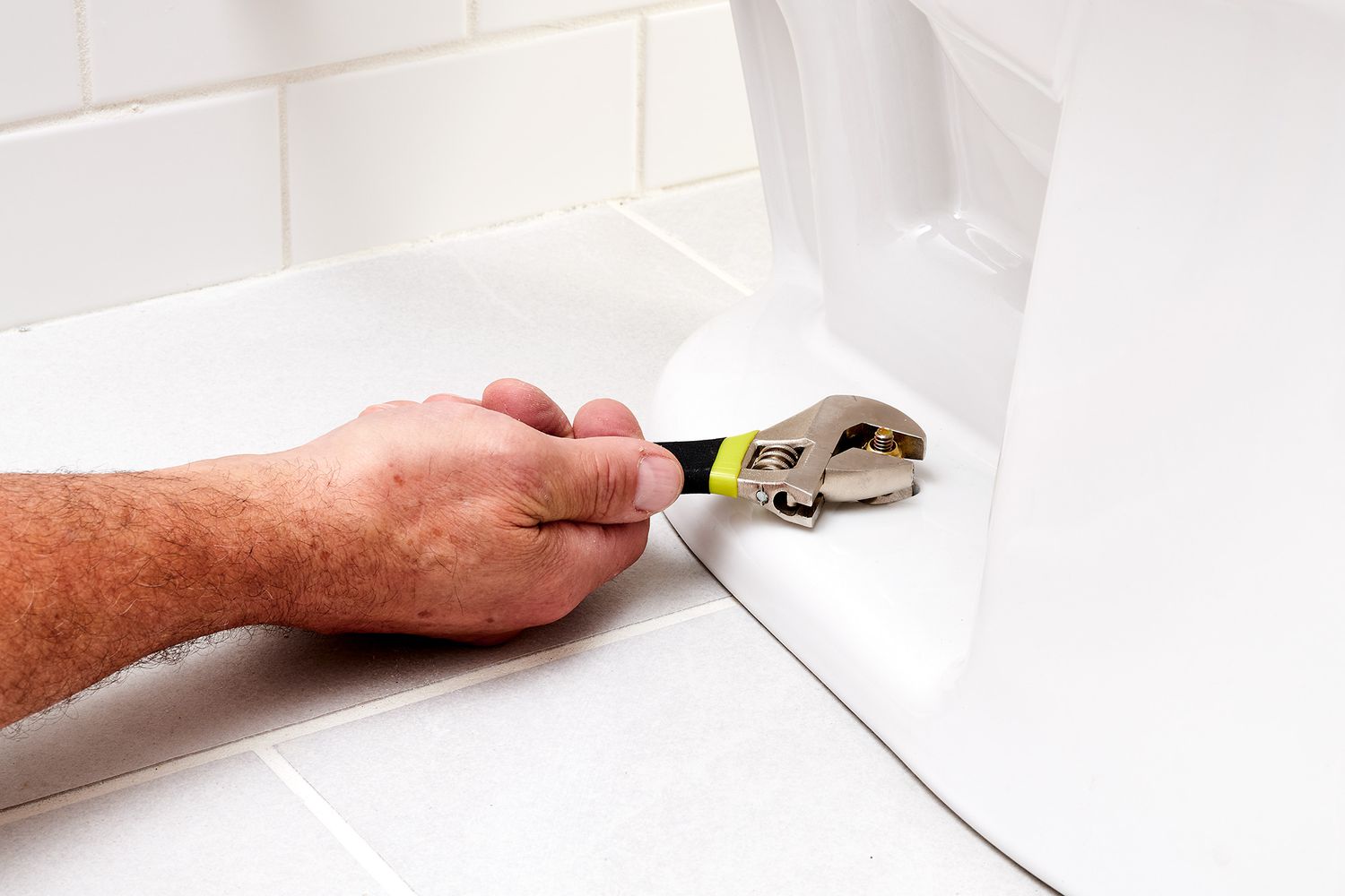 Bodenschrauben der Toilette mit verstellbarem Schraubenschlüssel gelöst