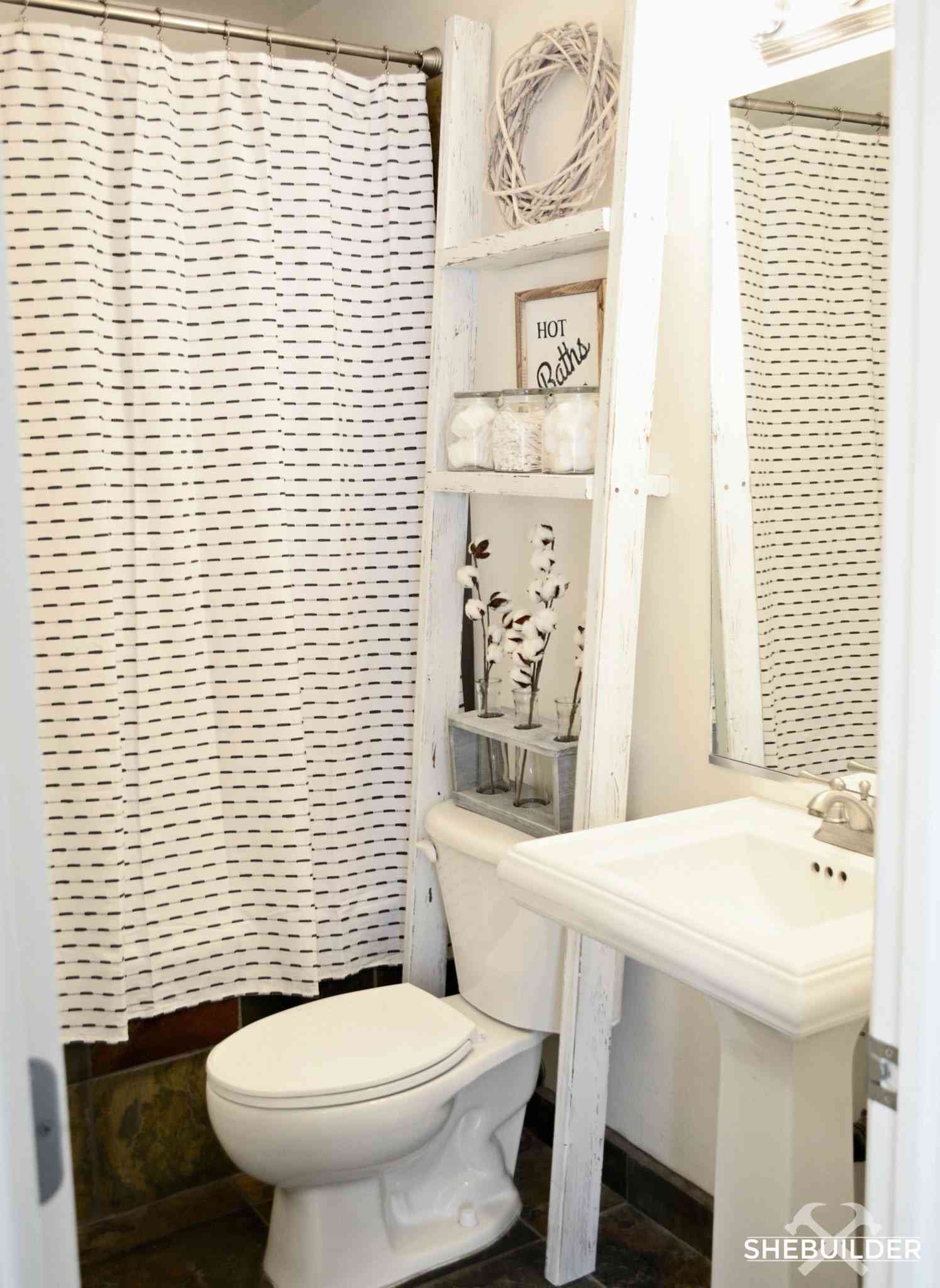 Ein weißes Badezimmer mit einer Leiter über der Toilette