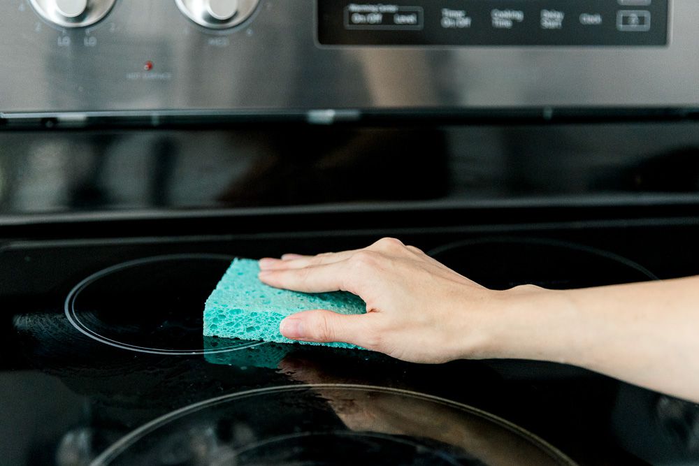 cleaning the cooktop with a sponge