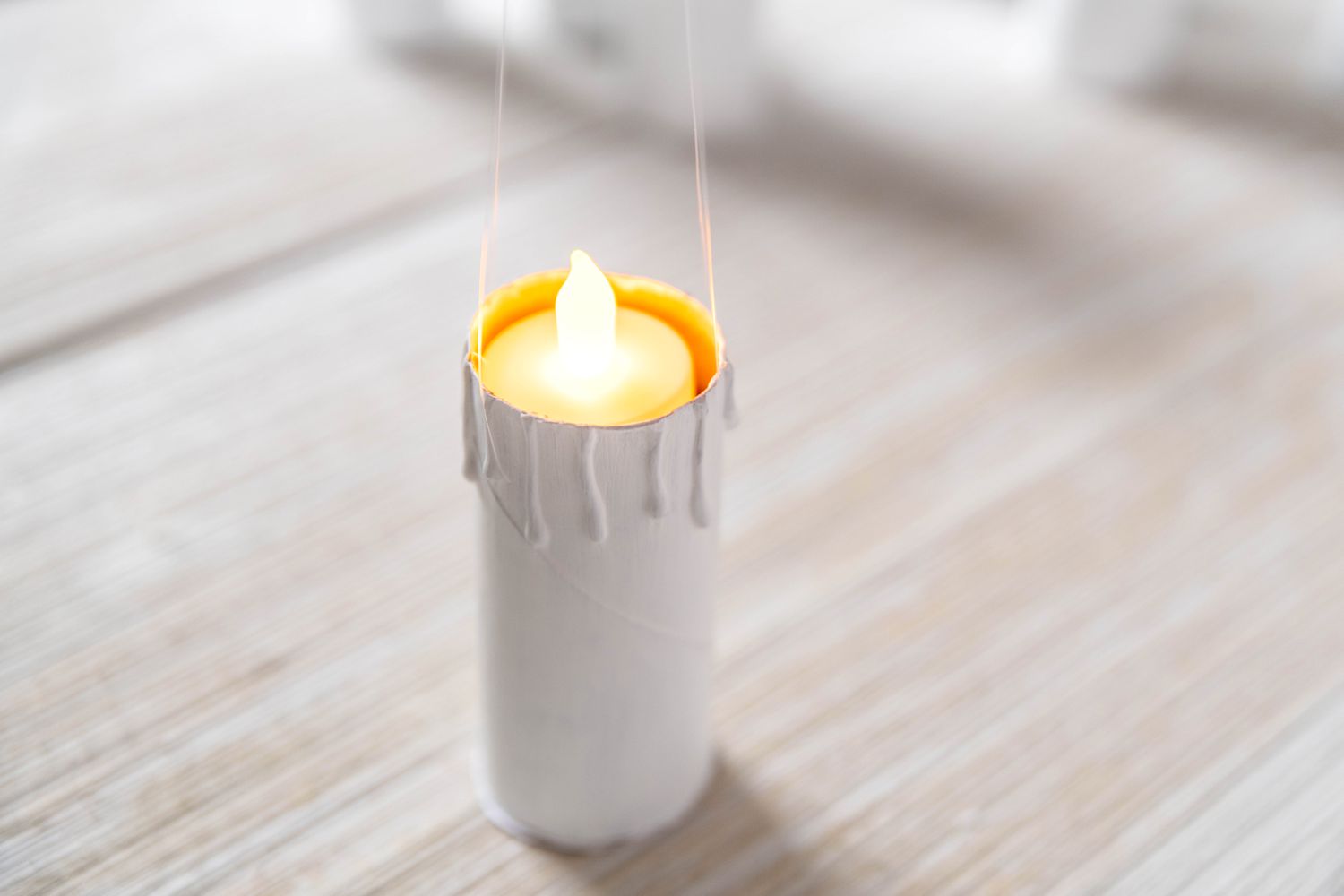 Battery powered tea light inserted into painted paper roll