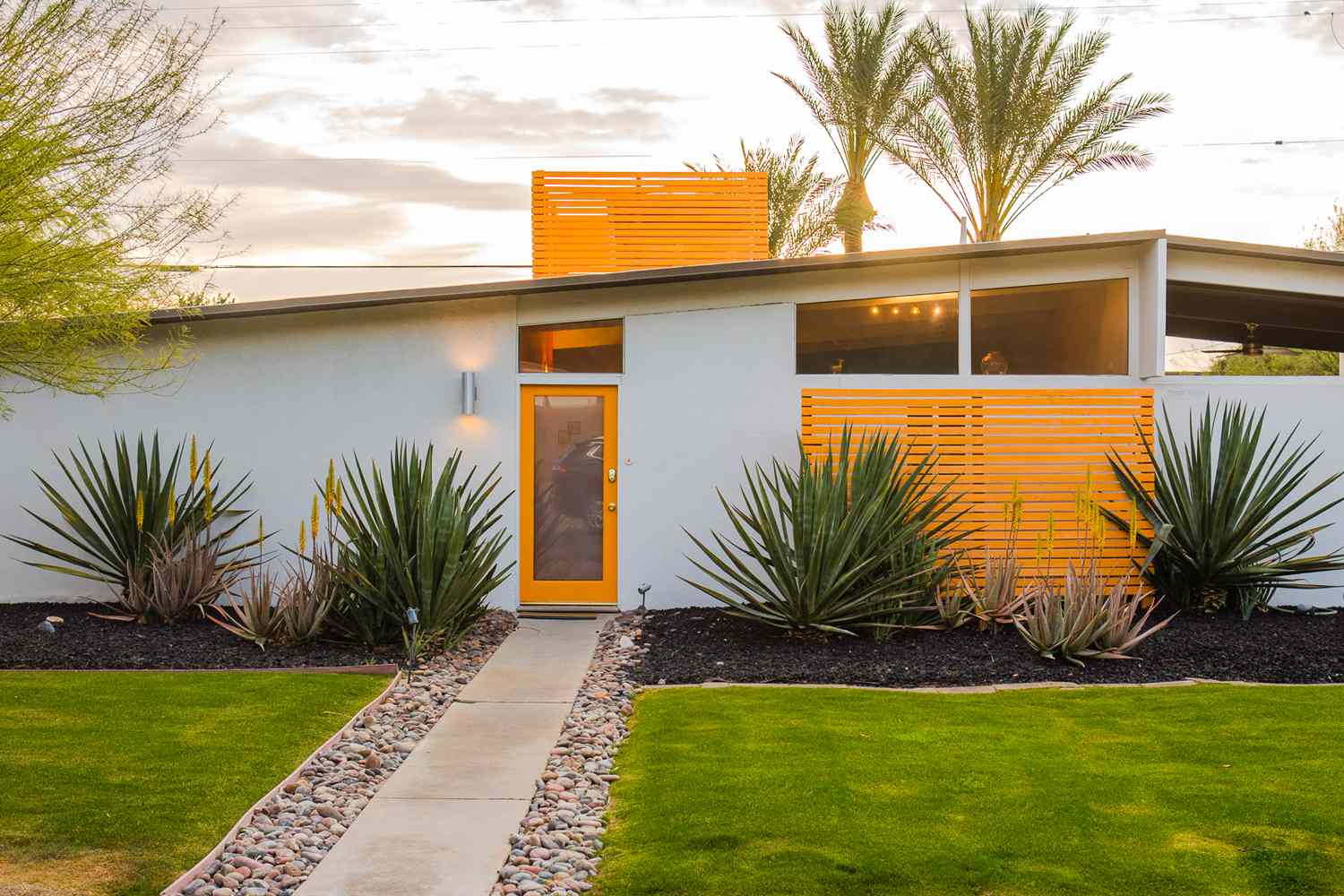 Modernes Haus mit schlanken Linien, orange lackierten Türen und Trennwänden