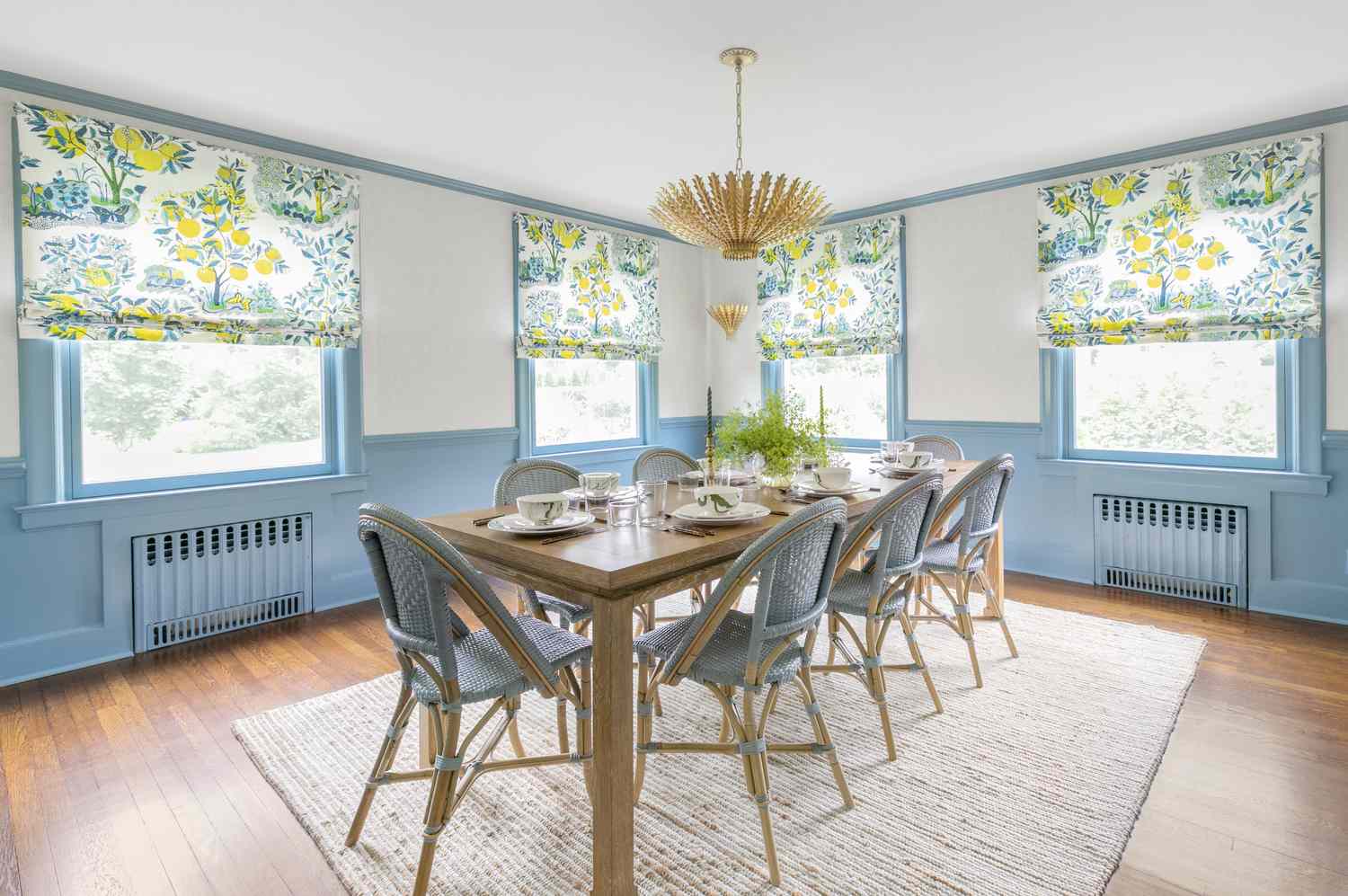 Grande salle à manger avec bordure de fenêtre bleue et teintes florales vives.