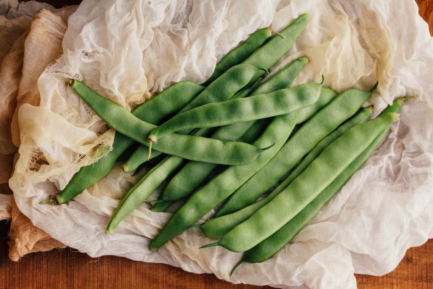 Green beens on white ruffled fabric