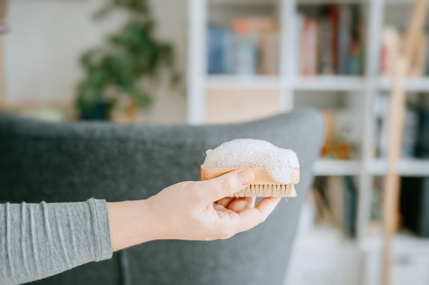 Soap suds on top of soft-bristled scrubbing brush