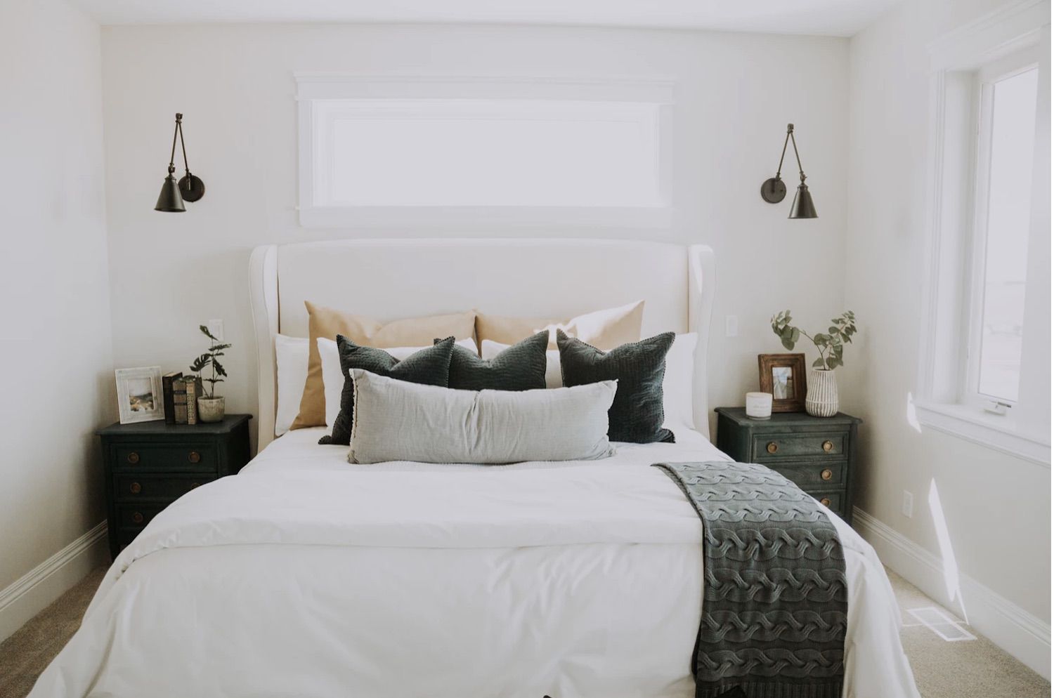 dormitorio moderno blanco con mesas de acento rústico de granja, apliques de metal