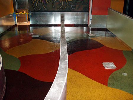revestimiento de suelo de hormigón pintado con epoxi con naranja, amarillo, marrón y verde.