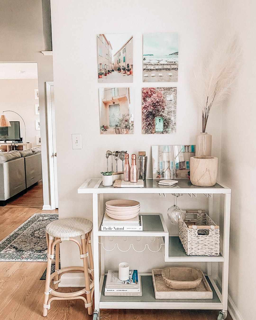 Photos hanging above shelving unit holding basket, books, and bowls