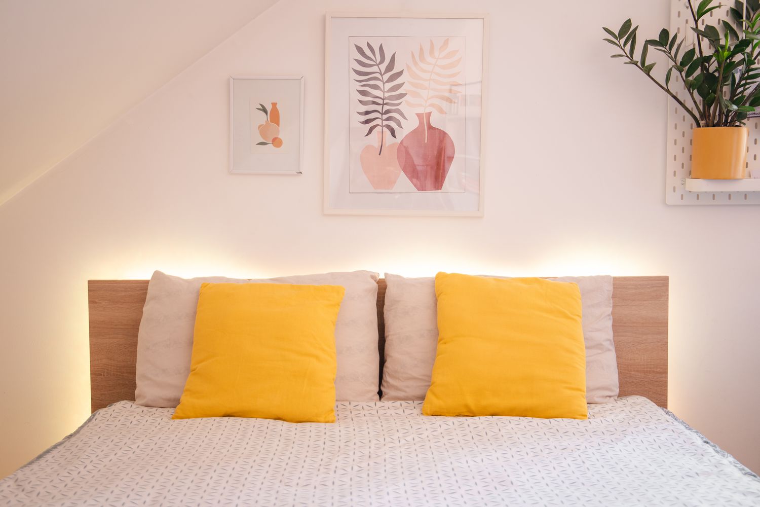 Gemachtes Bett mit gelben Wurfkissen, umgeben von Umgebungslicht