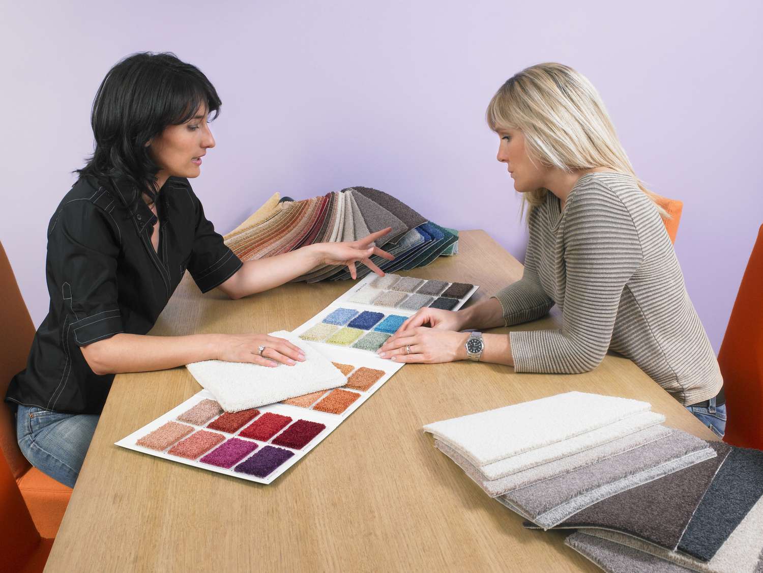 Designer mostrando amostras de carpete ao cliente.