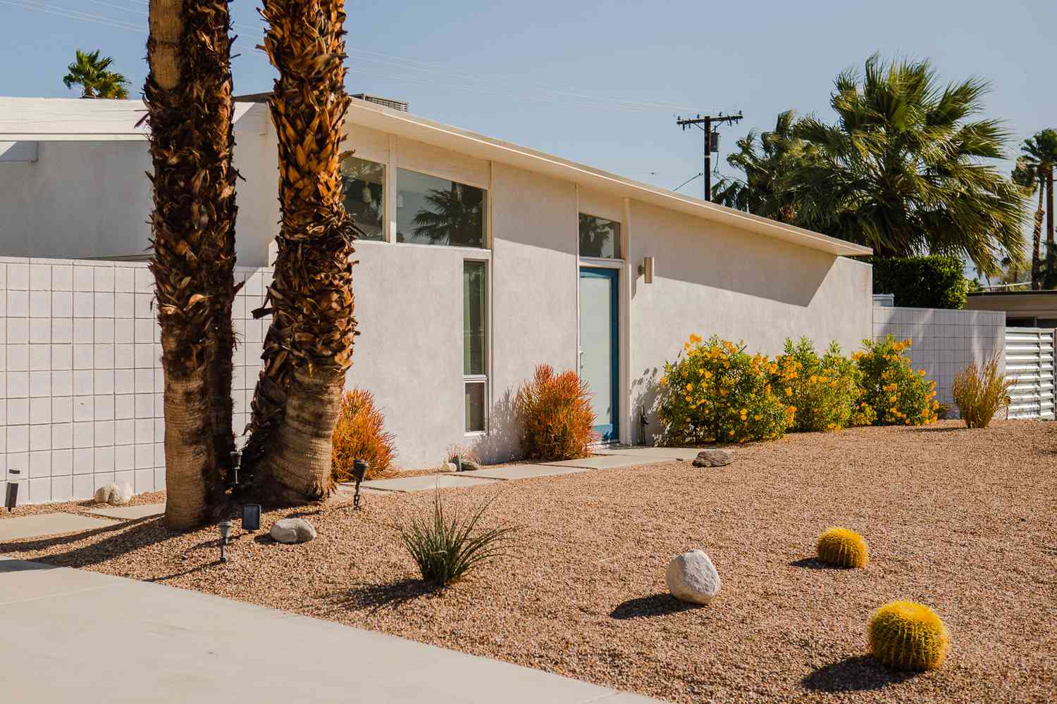 Außenansicht eines Hauses im Ranch-Stil mit minimalem Steingarten und Landschaftsgestaltung