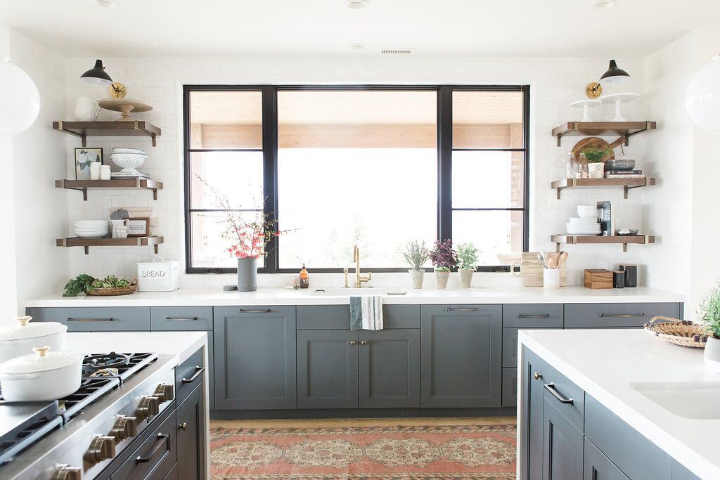 Cozinha com armários cinza-azulados e balcões brancos