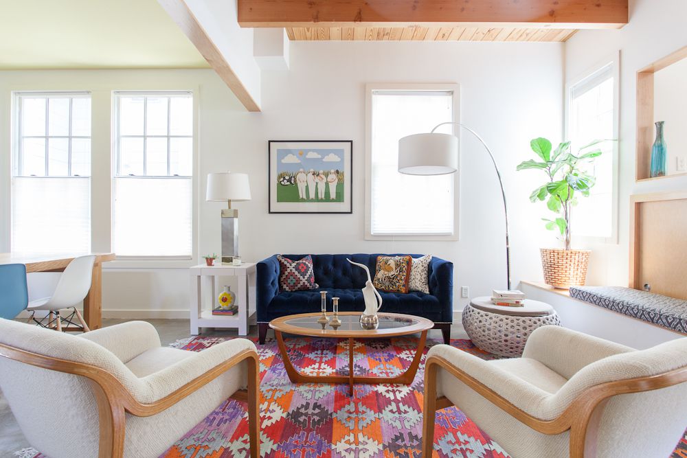 Wohnzimmer mit hellrosa Teppich und sichtbaren Holzdeckenbalken