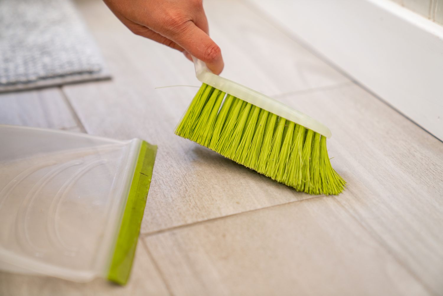 Le sol de la salle de bain balayé avec une brosse à main pour un nettoyage hebdomadaire