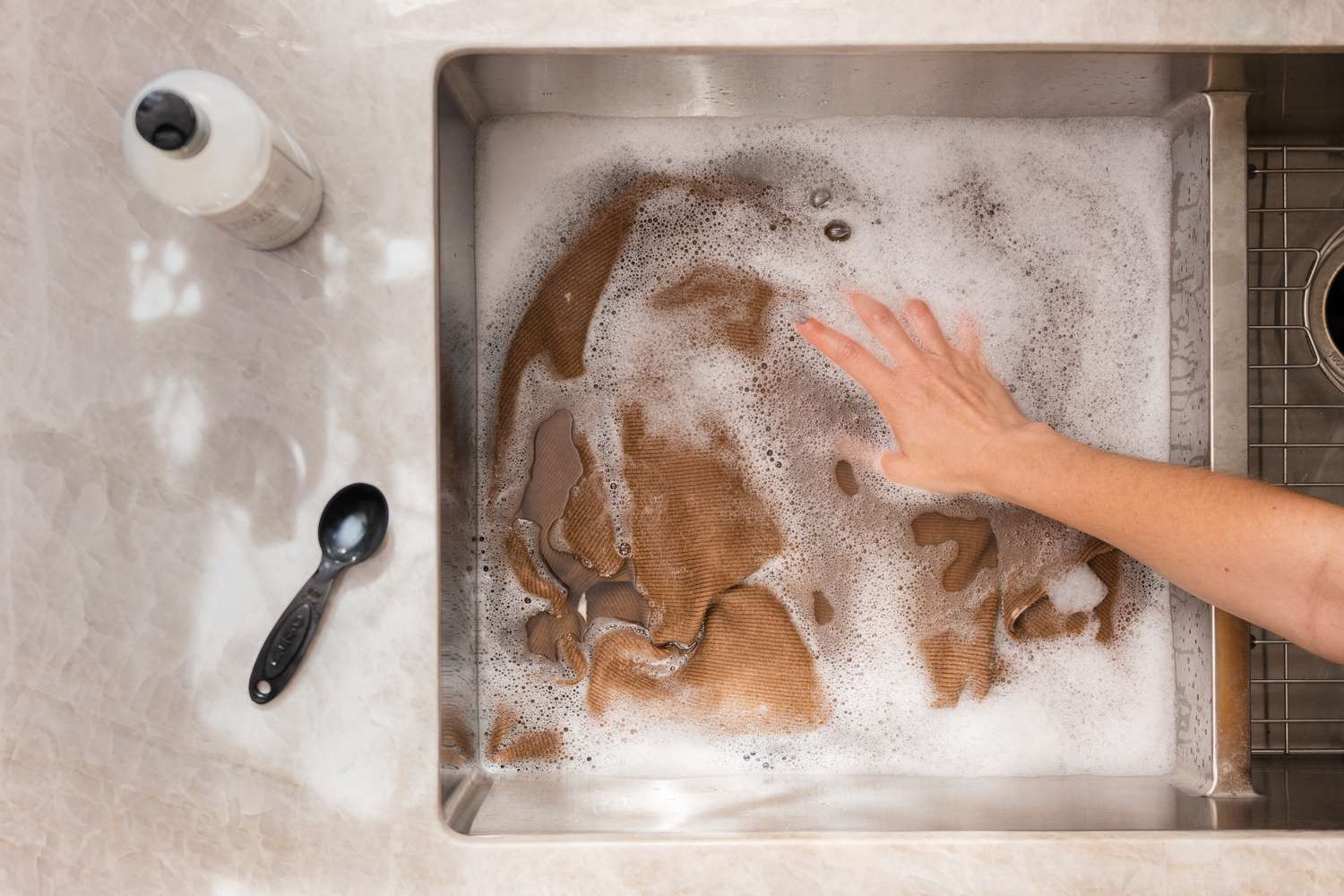 Handwäsche eines Wollpullovers im Waschbecken