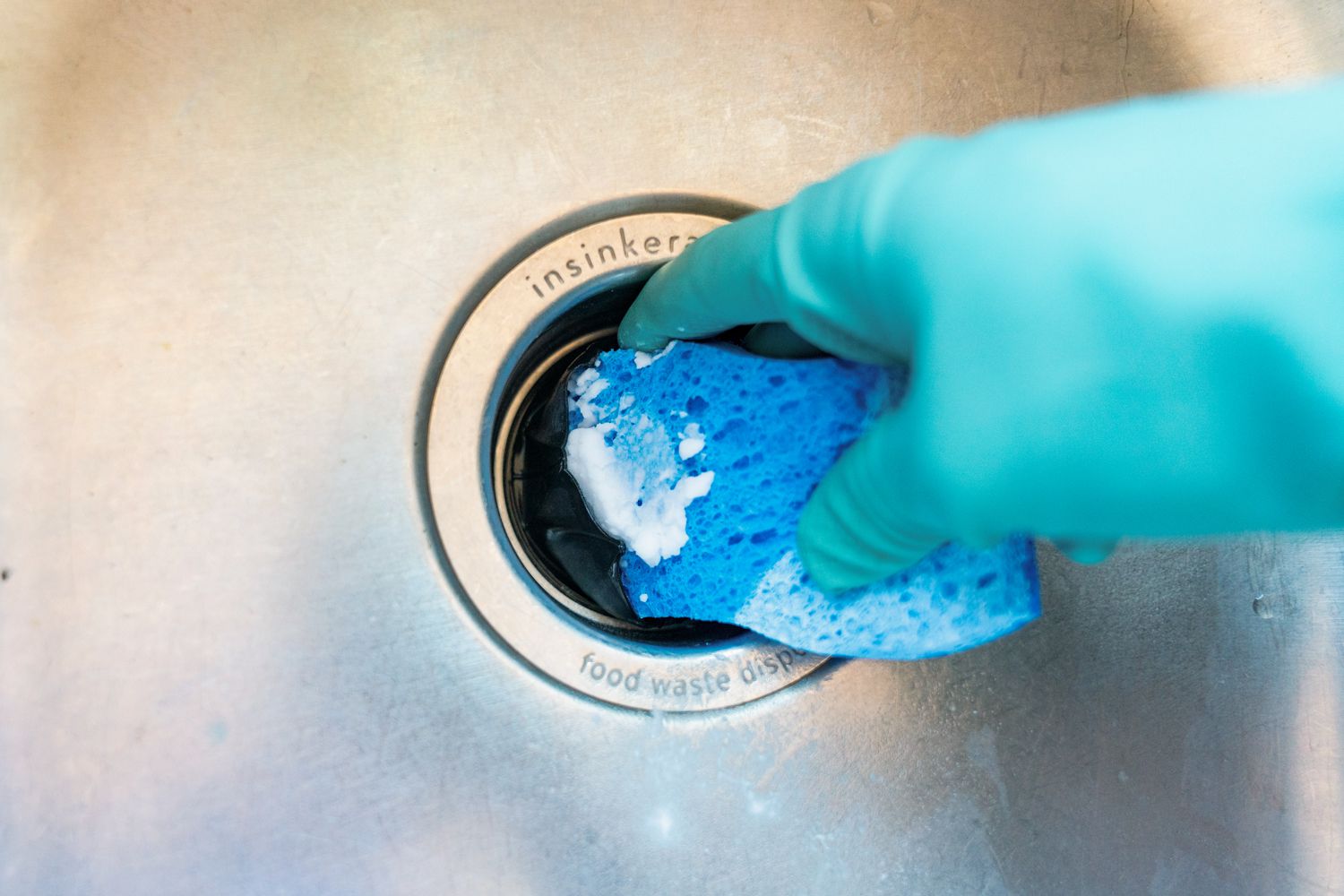 Schwamm mit Natronpaste zum Reinigen der Küchenspüle und des Müllschluckers