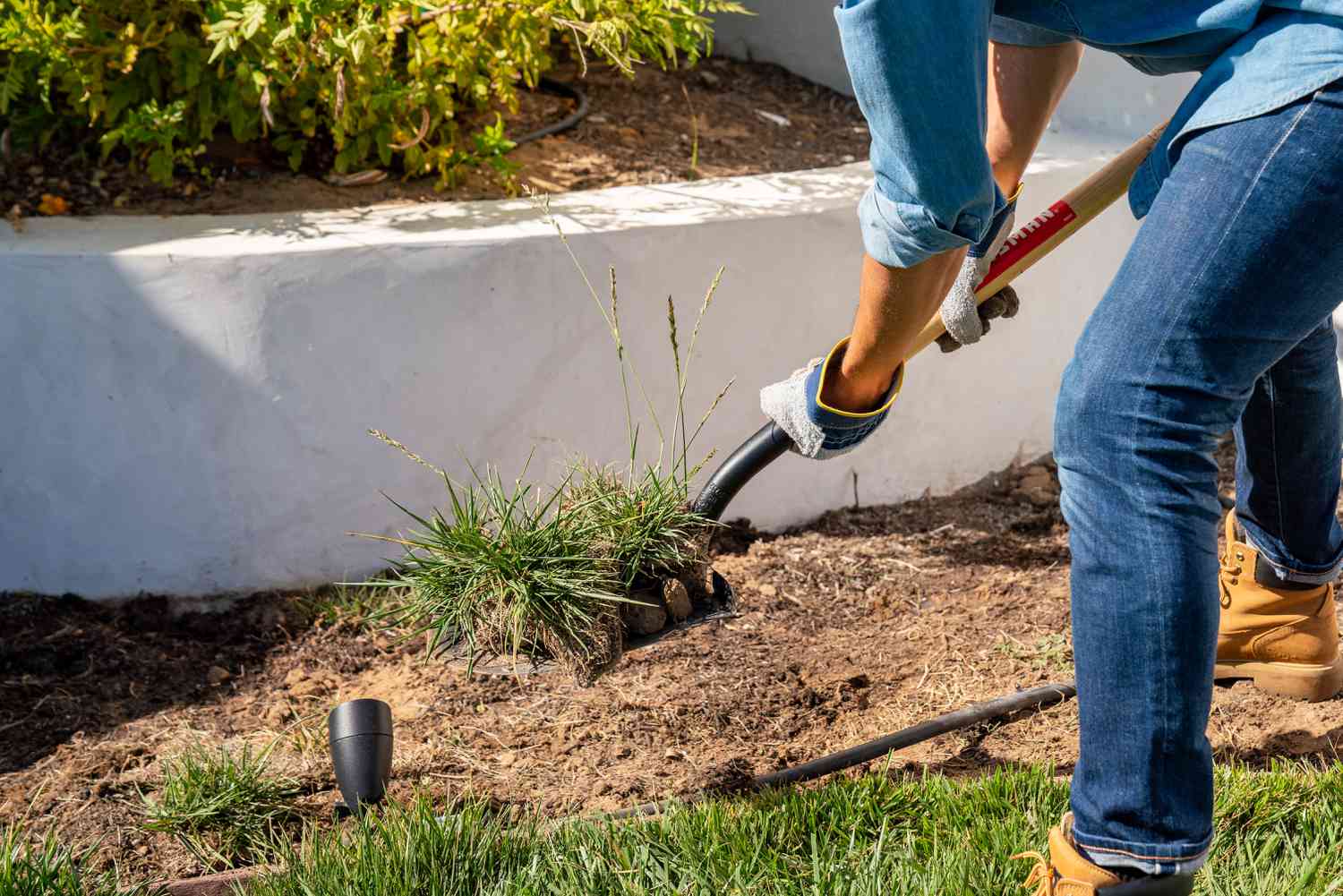 Mit der Schaufel entfernte Grasflecken zur Erweiterung des Gartenbeetes