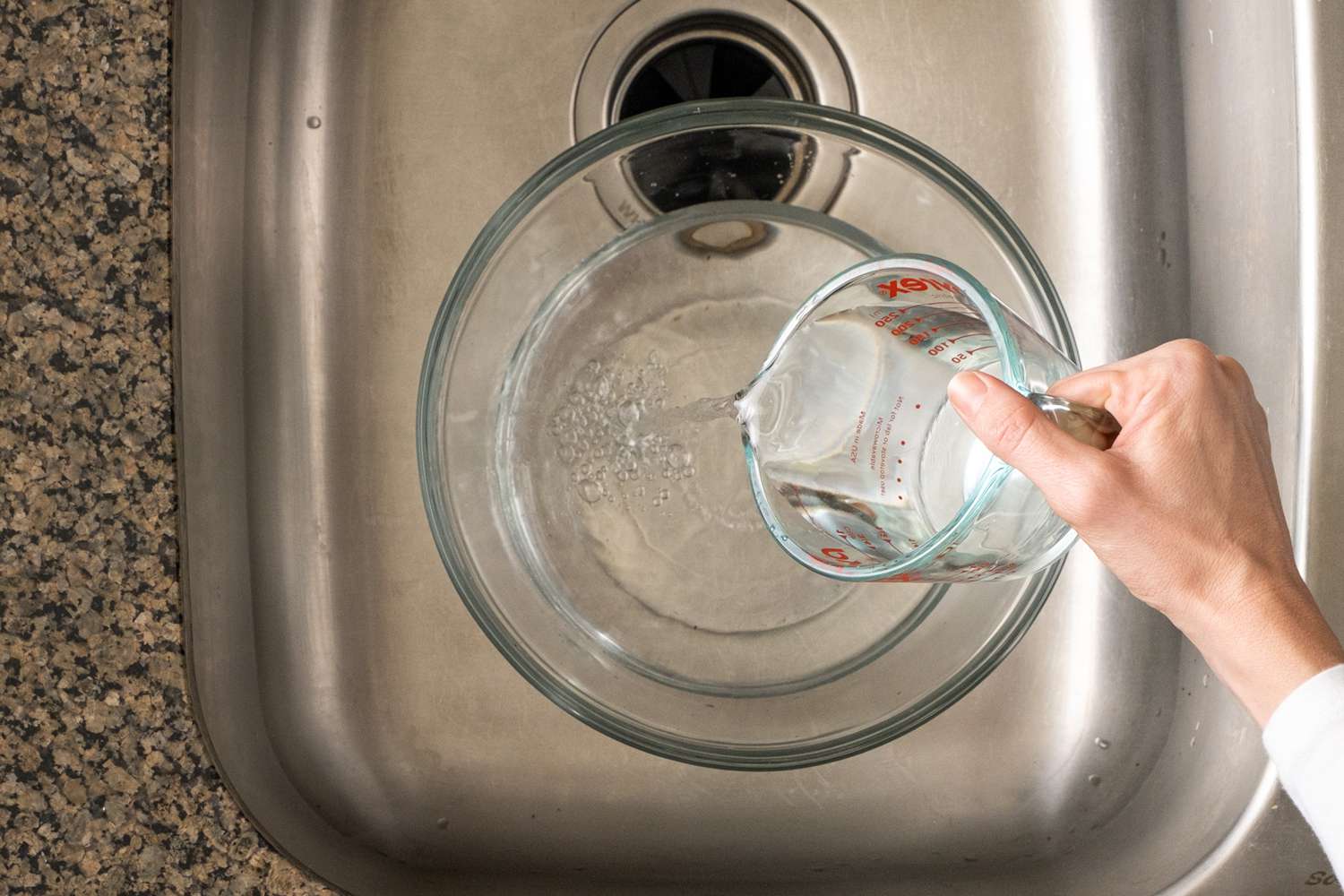 Água despejada em uma tigela de vidro para misturar a solução de limpeza