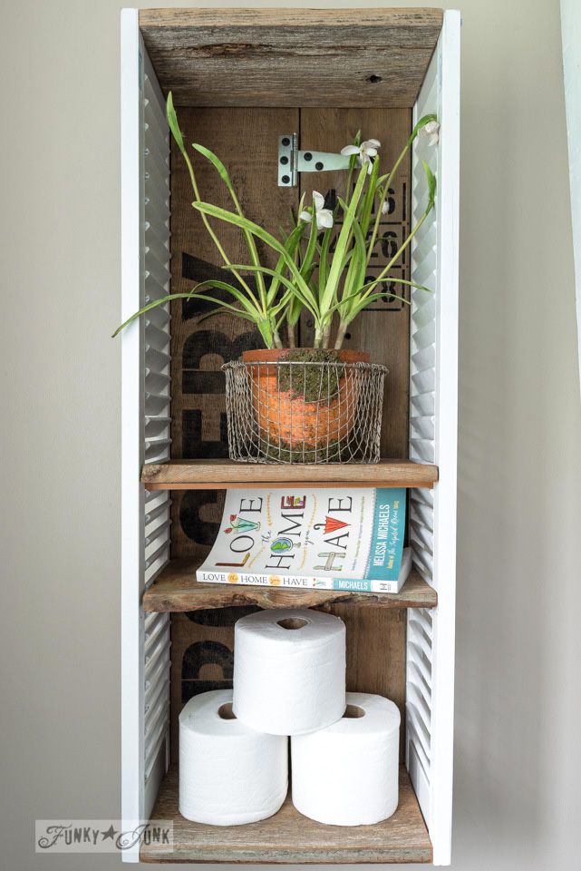 Ein Badezimmerschrank mit einer Pflanze und Seidenpapier