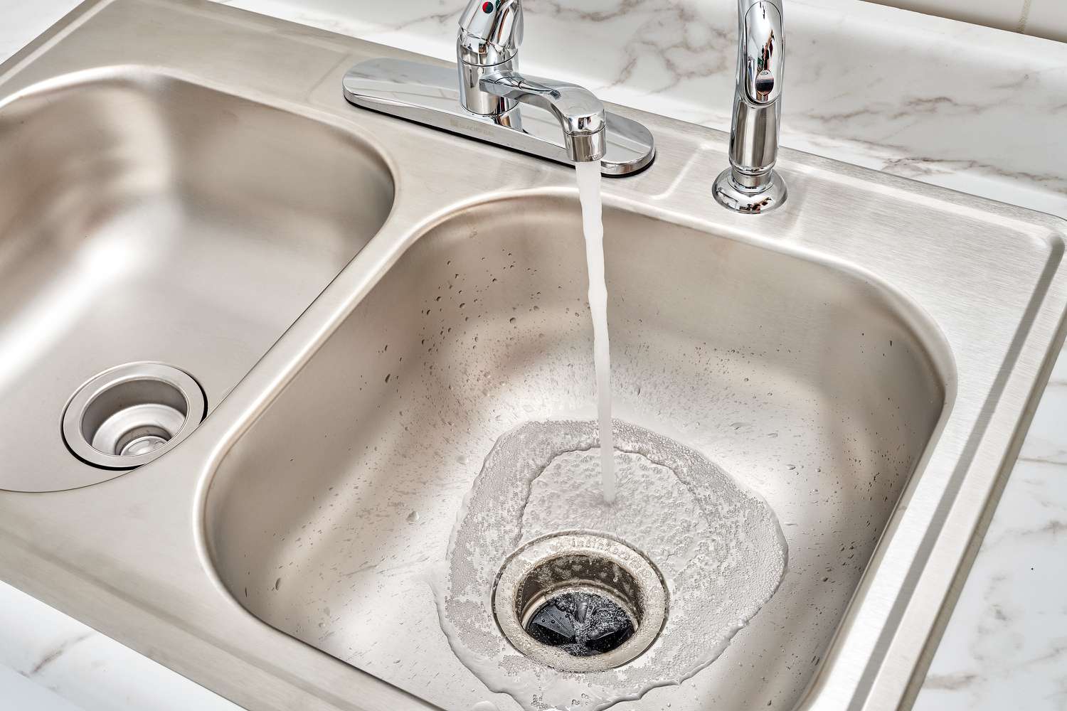 Water running down sink to check fro leaks with disposal