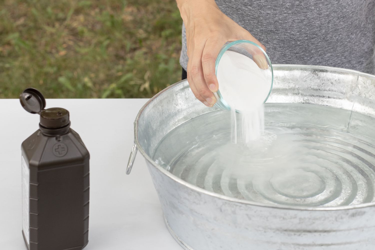 Wasserstoffperoxid und Backpulver in eine runde Metallschale mit Wasser gegossen