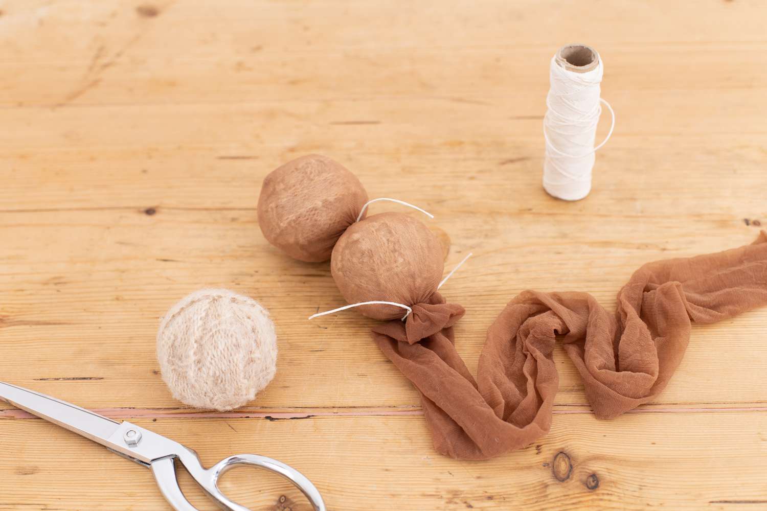 Strumpfhosenbein mit Trocknerkugeln umwickelt und mit Baumwollfaden abgebunden